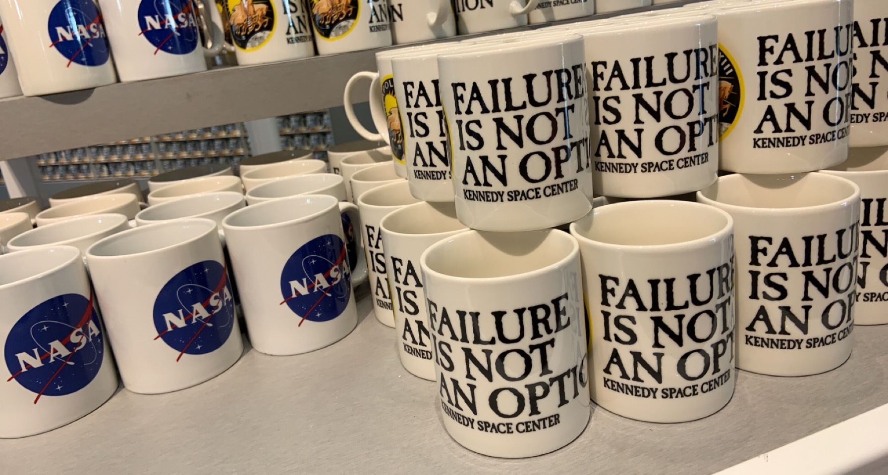 Shelves of Kennedy Space Center mugs printed FAILURE IS NOT AN OPTION