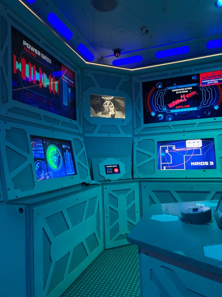 Immersive crisis-simulation room with failing power grid and offline comms displays
